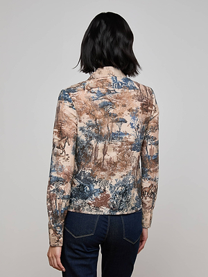 A person with short dark hair, seen from behind, is wearing the L'AGENCE Maia Printed Lace Blouse in brown and blue over dark blue jeans against a plain light background.