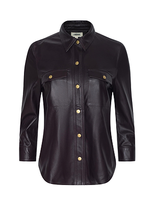 The Avina Leather Shirt by L'AGENCE features dark brown lambskin, long sleeves, a collar, two chest pockets, and gold front buttons. Displayed on a plain white background.