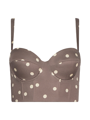 The Sonya Bustier is a brown cropped top in cardamom polka dot print with structured cups, adjustable straps, and a smocked back, made from lightweight twill. Shown against a plain white background.