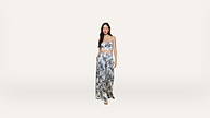 A woman stands against a plain white background, wearing a blue and white floral crop top with matching wide-leg pants and sandals.