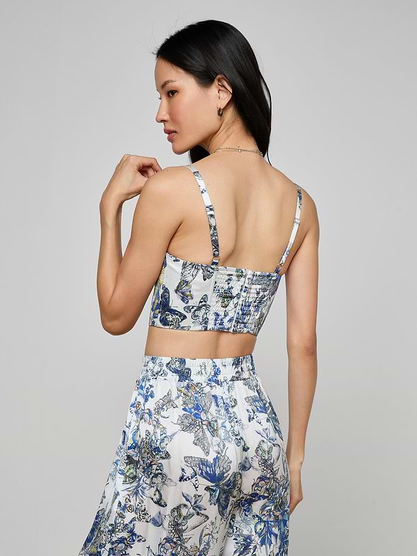 A woman is seen from the back, wearing the Sonya Silk Bustier and a matching skirt with a butterfly print. Her long dark hair cascades down against a neutral background.