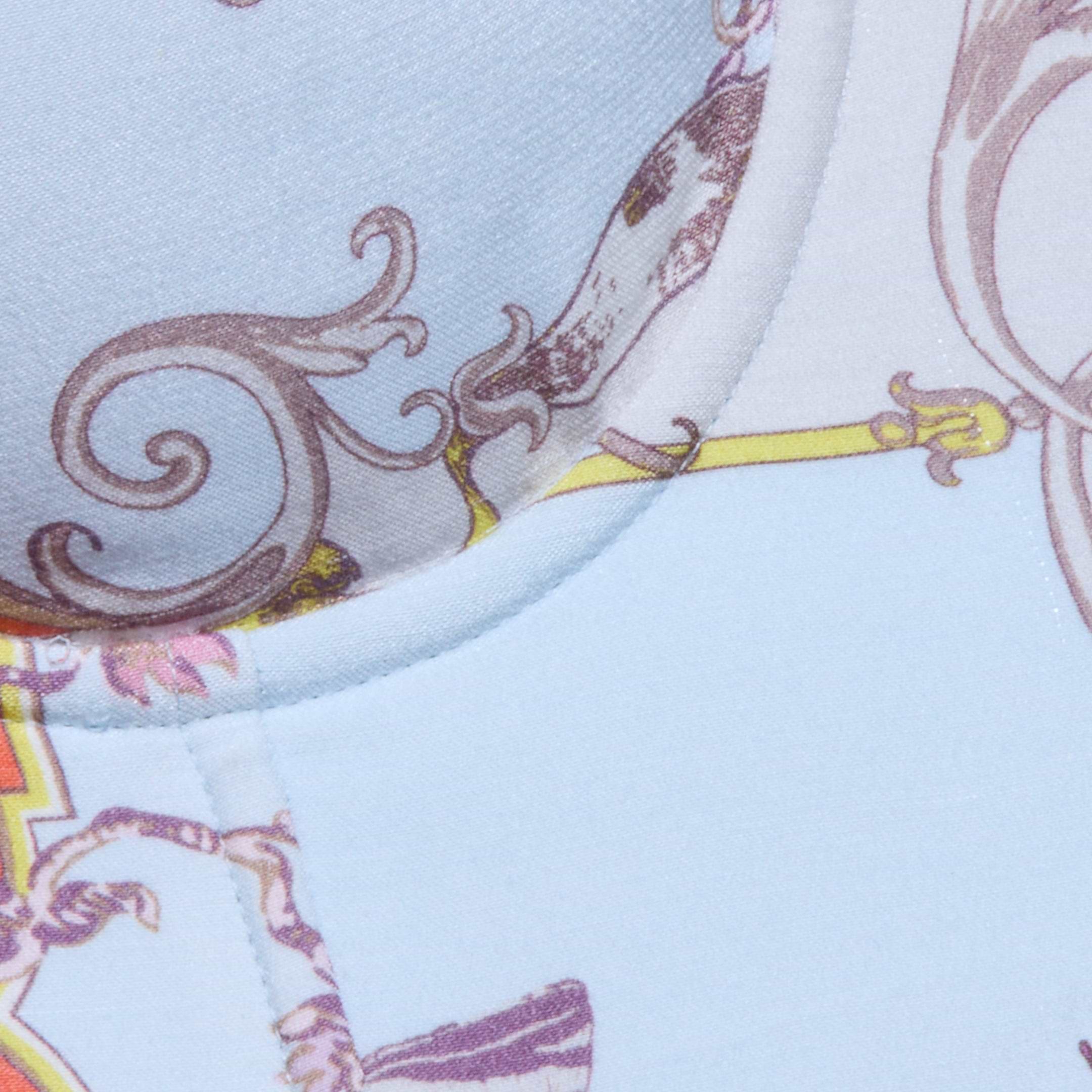 Close-up of the Sonya Bustier, crafted from lightweight twill with a light blue background adorned with decorative brown, purple, and yellow patterns. Swirling designs and ornate shapes evoke a baroque toile print, while visible stitching accentuates the curved seam.