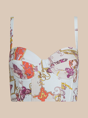 The Sonya Bustier is a colorful lightweight twill top with thin straps, showcasing a striking baroque toile print of gold scrolls, purple flowers, red accents, and ornate motifs on a light background.