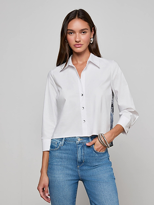 A woman with long brown hair wears the Fawn Panther Print Shirt and blue jeans, standing against a plain light background with one hand in her pocket and the other at her side.