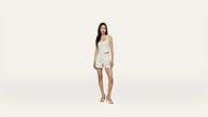 A woman stands against a plain white background, wearing a sleeveless striped top and matching shorts with sandals. She has long dark hair and a neutral expression.