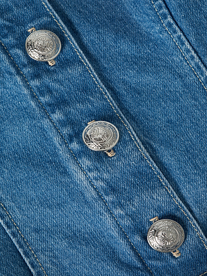 Close-up of blue denim fabric with three ornate silver buttons arranged in a vertical line.