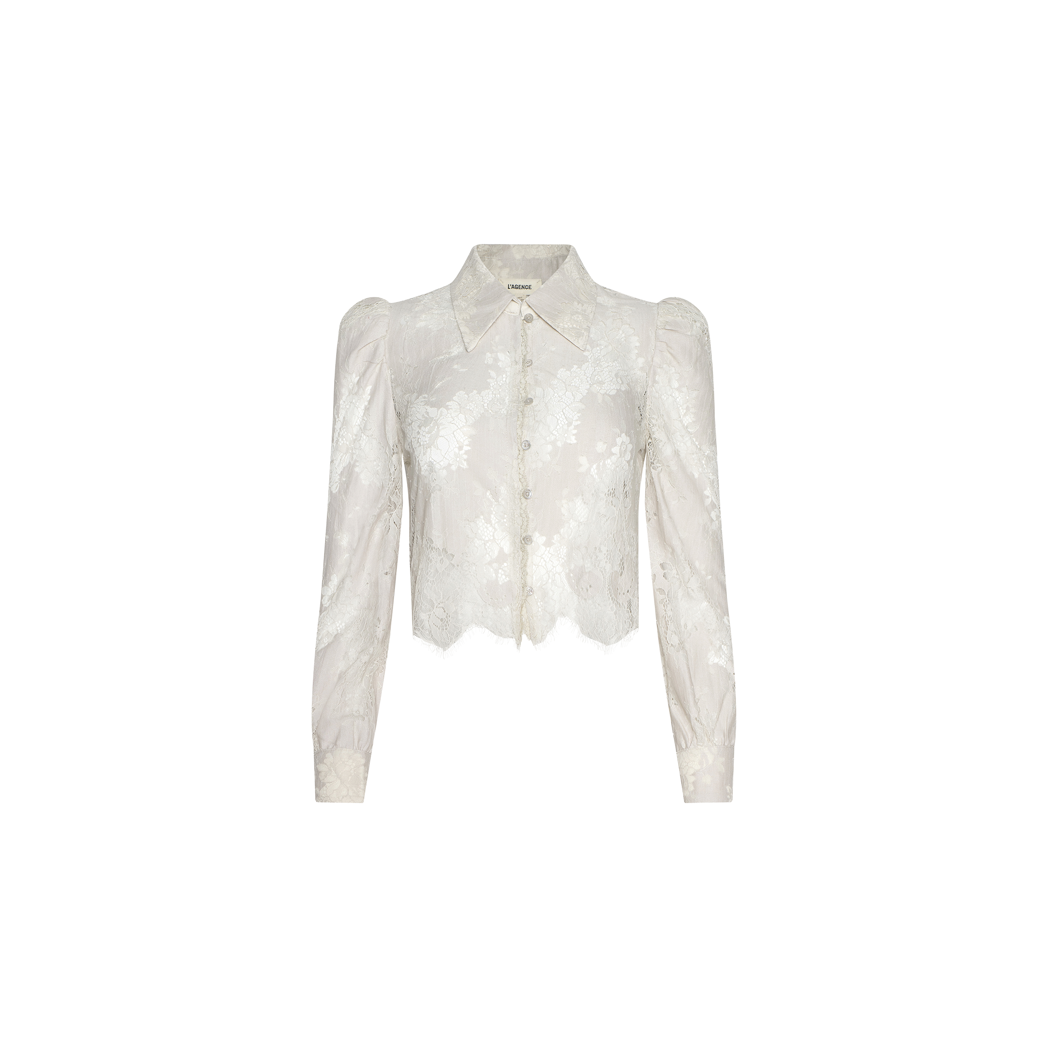 Introducing the Anita Lace Blouse: a sheer white floral lace blouse featuring long sleeves, a pointed collar, and front button closures. This cropped design showcases a slightly scalloped hem and is crafted from delicate, semi-transparent fabric.