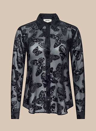 The Laurent Velvet Blouse is a sheer black long-sleeve burnout velvet top featuring a butterfly print, button-down front, and classic collar, displayed against a beige background.