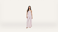 A woman stands against a plain white background, wearing a light pink, sleeveless top and matching wide-leg pants with open-toe shoes.