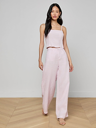 A woman wearing the Arlin Linen Tank in light pink paired with matching wide-leg pants walks forward against a plain white background.