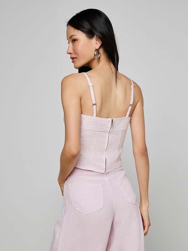 Woman with long black hair wearing the Arlin Linen Tank in light pink, paired with matching wide-leg pants, shown from the back against a plain light background.