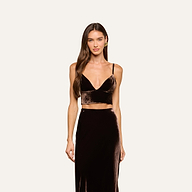 A woman with long brown hair wears the Aislin Velvet Bralette in java brown with adjustable straps, paired with a matching high-waisted skirt, standing against a plain light background and looking at the camera with a neutral expression.