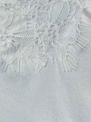 Close-up of the Kimber Silk Lace Camisole in light blue, showcasing delicate floral lace trim with fringe details atop a smooth, shiny satin-like silk fabric.