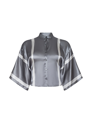 The Dru Silk Blouse is a cropped silk top featuring a mandarin collar, button-down front, wide kimono elbow sleeves, and vertical white stripes on the front and sleeves.