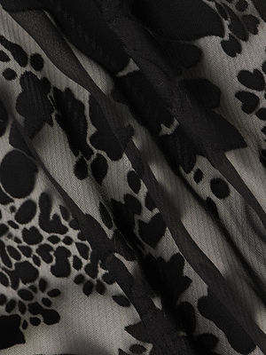 Close-up of the Rhett Burnout Satin Blouse by L’AGENCE, featuring sheer black abstract animal print on a light, translucent background. The fabric’s soft texture and gentle folds make it ideal for an oversized or bohemian blouse style.