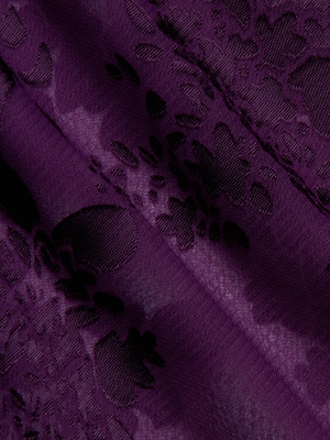 Close-up of the Rhett Burnout Satin Blouse by L'AGENCE, showcasing deep purple satin with a raised floral pattern and sheer, textured surface, highlighted by subtle folds.