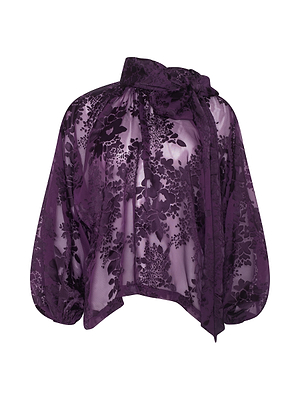 The Rhett Burnout Satin Blouse by L'AGENCE features sheer purple satin with a floral pattern, balloon sleeves, and a large bow tie at the neckline. Its lightweight, semi-transparent fabric adds an elegant touch.