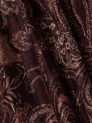 Close-up of the Rhett Oversized Blouse by L'AGENCE, featuring a dark brown paisley print with intricate light brown floral and leaf motifs. The textured fabric drapes softly, lending a stylish, bohemian feel.