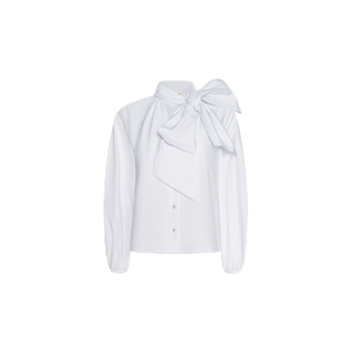 The Deon Tie-Neck Blouse is a white, long-sleeve top crafted from organic cotton poplin, showcasing front buttons and an oversized dramatic neck tie at the neckline. Featuring a collar, elegant blouson sleeves, and a loose fit, the blouse is displayed on a plain white background.