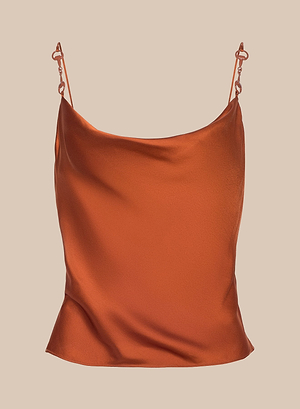 The Calista Satin Camisole, shown in burnt orange with thin spaghetti straps and a cowl neckline, features a silky, bias-cut satin design and is displayed on a plain beige background.