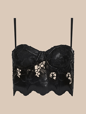 Le bustier en cuir végétal Sonya, doté dune superposition de dentelle noire à motifs floraux, de bretelles réglables et dun ourlet festonné, sinspire du design des bustiers à armatures et se présente sur un fond beige.