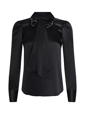 The Honey Silk Blouse is a long-sleeved black silk top with structured shoulders, wide cuffs, and a large bow tie neckline. Its smooth, shiny fabric stands out against the white background.