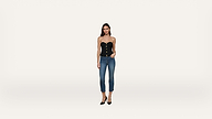 A woman wearing a black strapless top with buttons, blue cropped jeans, and black heels stands against a plain white background.