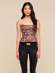 Woman with long dark hair wearing the Meliora Corset Peplum Top styled with black pants, standing against a plain light background.