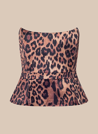 The Meliora Corset Peplum Top is a strapless, fitted peplum corset featuring a bold leopard print pattern, shown against a plain beige background.
