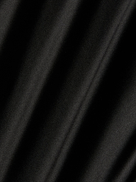 A close-up of the Orlina Silk Camisole in black, highlighting its luxurious silk fabric with soft diagonal shadows and folds that form a pattern of alternating light and dark areas.