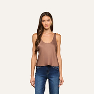 A woman with long brown hair wears the Eddie Tank, a sleeveless cardamom brown satin top with a scoop neckline, paired with blue jeans. She stands against a plain light background, facing forward with a neutral expression.