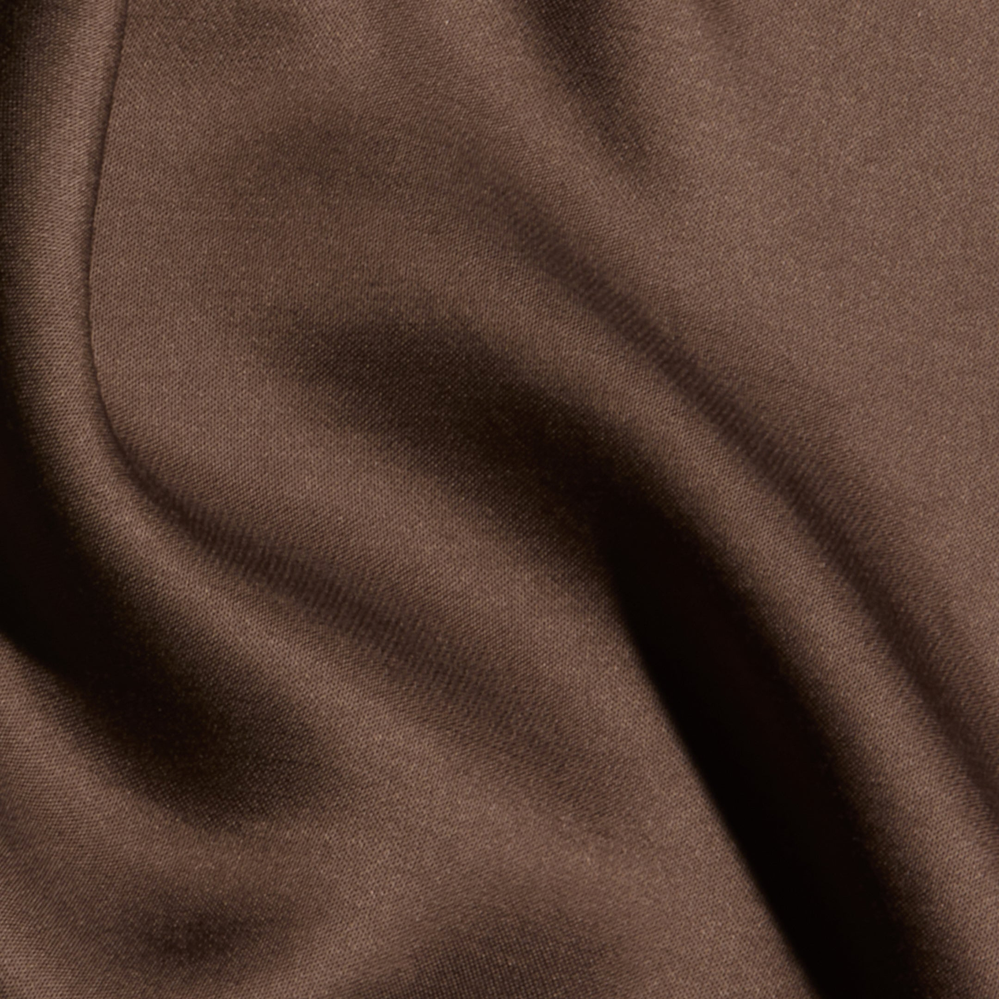 Close-up of the Eddie Tank in smooth, cardamom brown bias-cut satin, with soft folds and gentle shadows that create a sense of texture and movement.