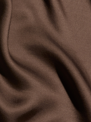 Close-up of the Eddie Tank in cardamom brown satin, showcasing its smooth texture and gentle, flowing folds reminiscent of bias-cut satin, with soft shadows and highlights playing across the surface.