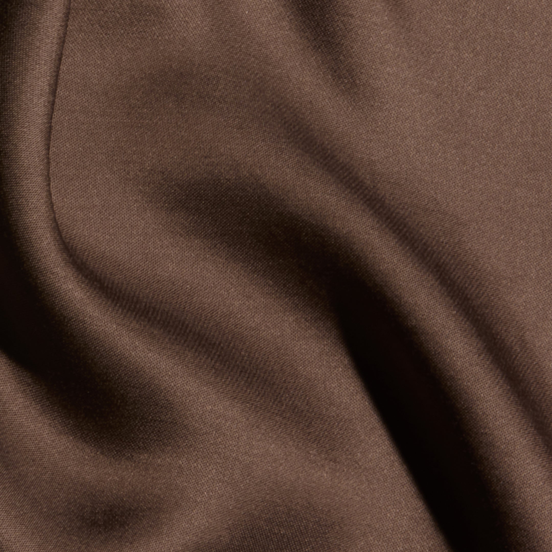 Close-up of the Eddie Tank in smooth, cardamom brown bias-cut satin, with soft folds and gentle shadows that create a sense of texture and movement.