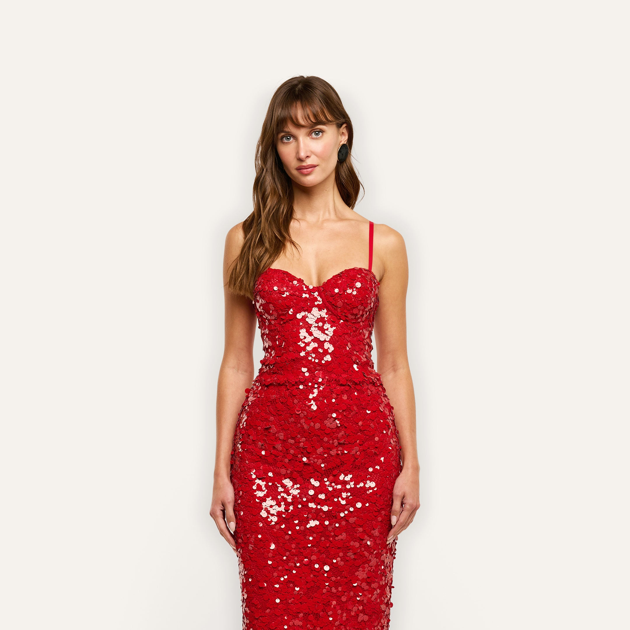 A person wears a Lior Sequin Top in red with a sequined, spaghetti-strap sweetheart neckline and structured cups.