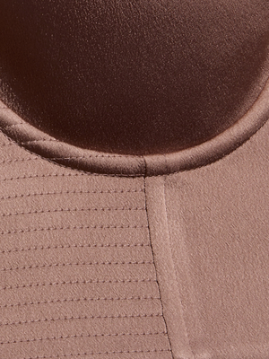 Close-up of light brown, textured fabric with stitching and curved seams from the Nysa Bustier Top, designed for a supportive fit.
