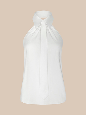 The Wren Top is a sleeveless, white sateen cotton top with a halter button-down design, pointed collar, and necktie detail, shown on a plain beige background.