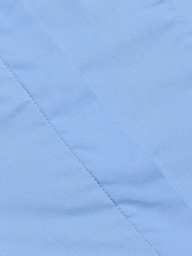 Close-up of light blue fabric with a diagonal seam and visible stitching detail, showcasing the smooth texture that makes it ideal for the Rina Poplin Halter Top.