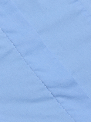 The Rina Poplin Halter Top features light blue organic cotton-blend fabric with diagonal stitching, a soft, smooth surface, and subtle shadows along the seams—perfectly quilted for an airy summer style.