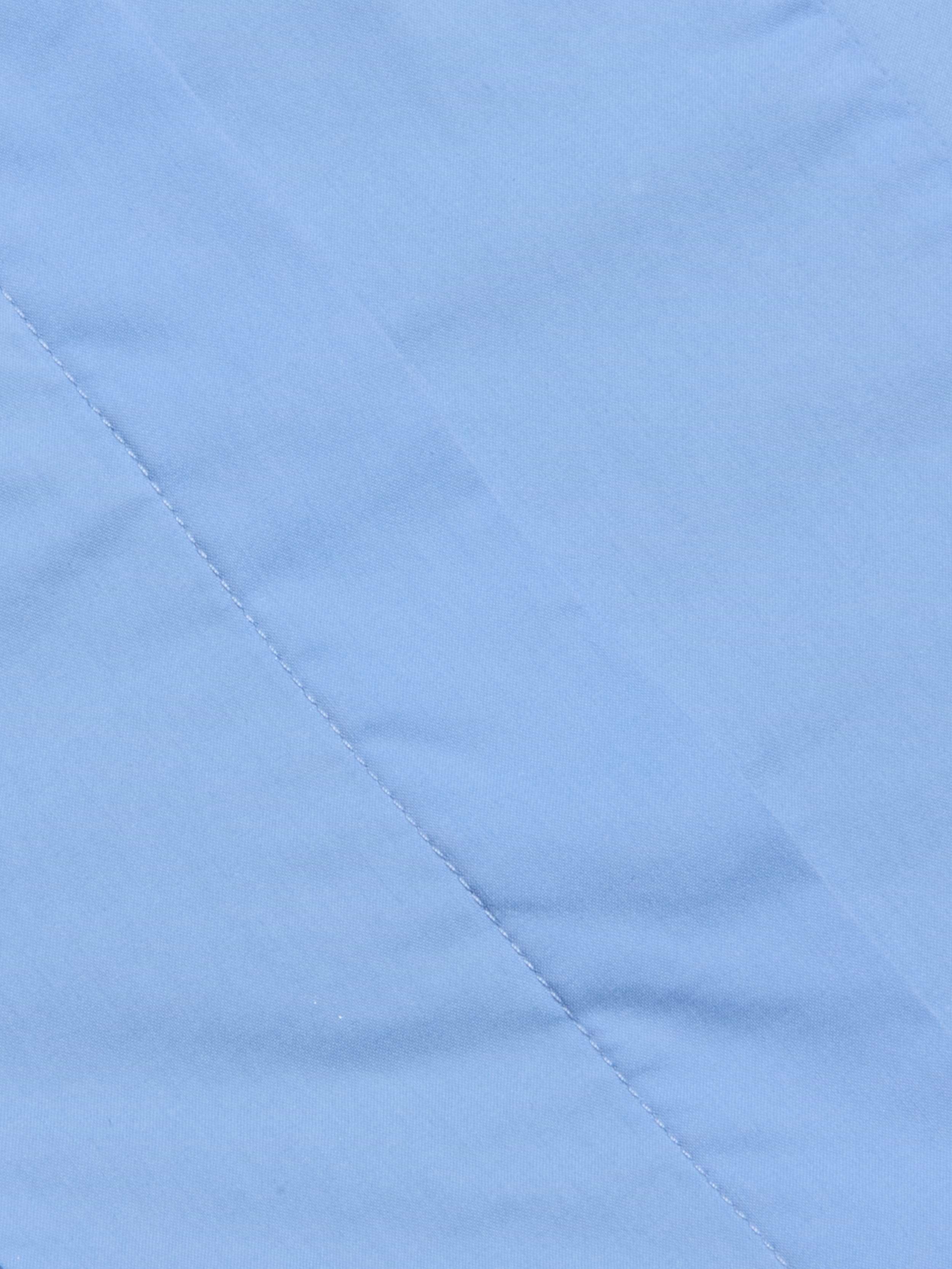 Close-up of light blue fabric with a diagonal seam and visible stitching detail, showcasing the smooth texture that makes it ideal for the Rina Poplin Halter Top.