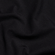 A close-up of the Sarai Off-The-Shoulder Top in black organic cotton-blend fabric, featuring subtle folds and wrinkles that highlight its smooth texture and soft sheen.