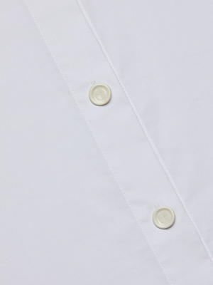 Close-up of the Rylie Poplin Shirt, a white button-down dress shirt made from smooth organic cotton, featuring part of the button placket with two neatly sewn white buttons.