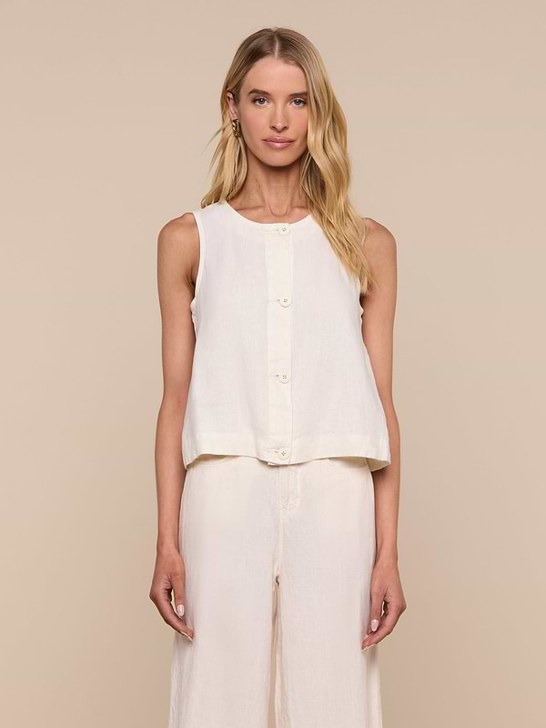 A woman stands facing forward against a plain light background, wearing the sleeveless Foster Linen Top with an A-line silhouette, paired with matching wide-leg pants.