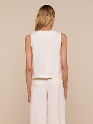 A woman with long blonde hair is shown from the back, wearing the sleeveless Foster Linen Top and matching wide-leg pants with an A-line silhouette against a plain light background.