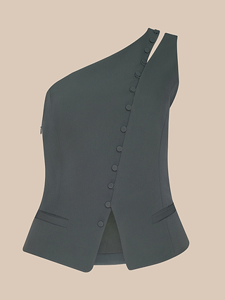 The Zinnia One-Shoulder Top is a dark green ash olive, sleeveless piece with sculptural tailoring, an asymmetrical one-shoulder design, a slanted row of buttons, and two front slit pockets, displayed on a beige background.