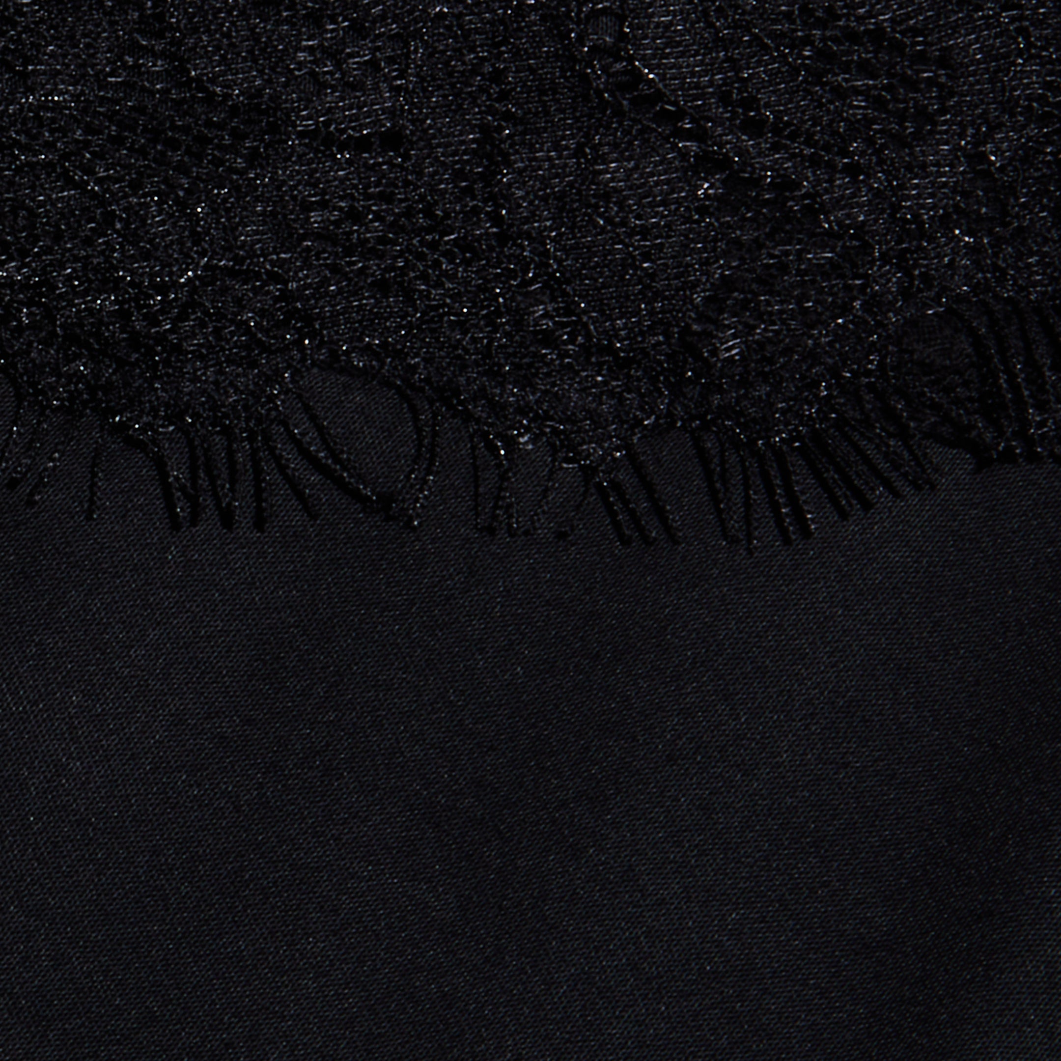 Close-up of the black lace trim with a fringed edge, layered over the smooth satin fabric of the Elka Satin Lace Camisole.