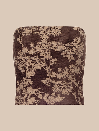 The Paulette Corset Top is a strapless brown and beige jacquard piece, featuring a delicate floral pattern on a solid background and displayed against a plain beige backdrop—perfect for the fashion-forward wardrobe.