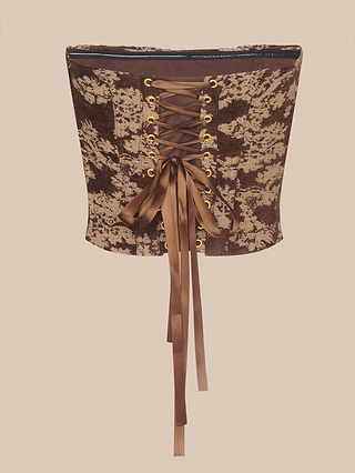The Paulette Corset Top is a fashion-forward brown and beige lace corset featuring a back lace-up design with gold eyelets and long satin ribbons, elegantly detailed in floral jacquard and showcased on a plain background.