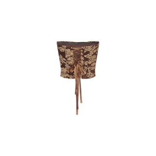 The Paulette Corset Top is a brown and beige floral jacquard design featuring gold eyelets, a ribbon lace-up back, and trailing satin ties, shown against a plain white background.