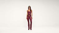 Woman in burgundy lace top and matching burgundy leather pants stands facing forward, wearing sunglasses and heels, with a neutral white background.